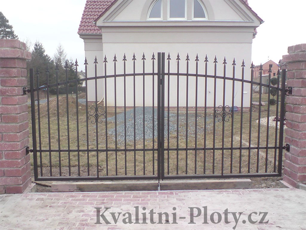 Dvoukřídlá kovaná brána s hroty před novostavbou
